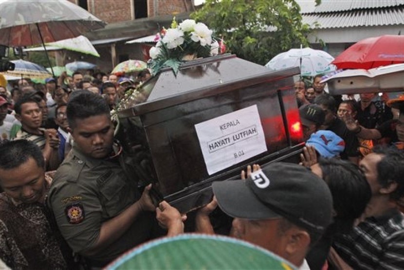 Relatives carry the coffin containing the body of Hayati Lutfiah hamid, one of the victims of AirAsia Flight 8501, during her burial at a cemetery in Surabaya, East Java, Indonesia, Thursday, Jan. 1, 2015. 