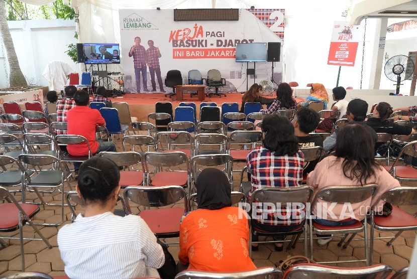 Relawan Basuki-Djarot menyaksikan proses persidangan perdana Gubernur DKI Jakarta Non-Aktif Basuki Tjahaja Purnama (Ahok) melaui layar televisi di Rumah Lembang, Jakarta, Selasa (13/12). 