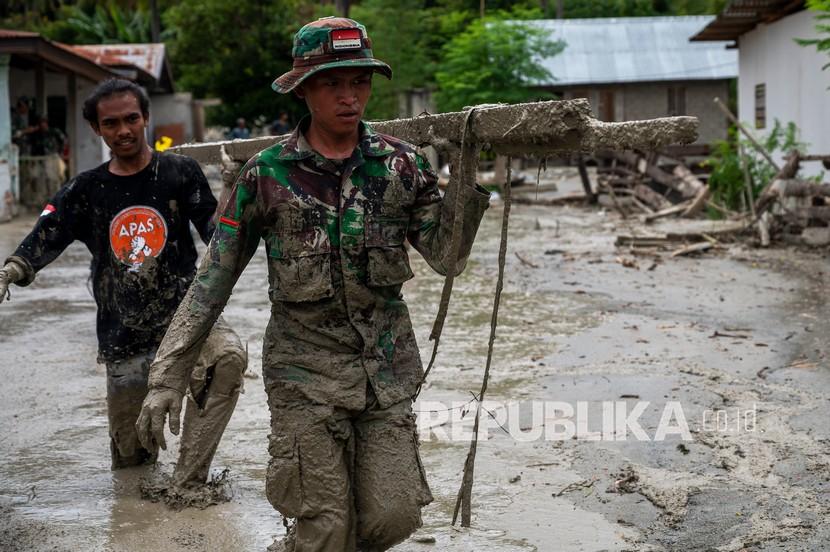 Relawan bersama prajurit TNI membersihkan sisa material dan lumpur yang menggenangi rumah warga di Desa Beka, Marawola, Kabupaten Sigi, Sulawesi Tengah, Sabtu (27/3/2021). Banjir lumpur yang terjadi pada Jumat (26/3) malam itu disebabkan oleh longsor pasca hujan deras di pegunungan dan menyapu pemukiman di wilayah tersebut dan mengakibatkan 70 rumah warga rusak berat, lebih dari 100 unit rumah rusak ringan dan sebanyak 200 warga terpaksa diungsikan. 