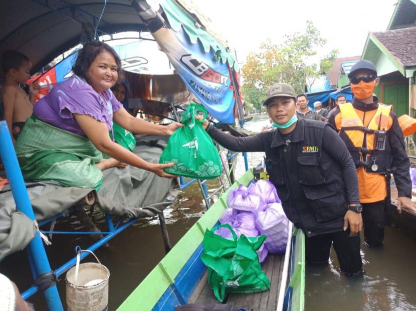 Relawan BMH, AQL Peduli dan SAR Hidayatullah menggunakan jukung (perahu) untuk mengantarkan bantuan kepada warga korban banjir di Kabupaten Banjar, Kalimantan Selatan.