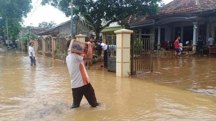 Relawan BMH menerjang banjir untuk mengantarkan paket bantuan kepada warga di Desa Kutorenon, Lumajang, Jatim.