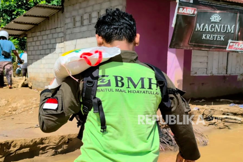 Relawan BMH menyusuri lumpur untuk menyalurkan bantuan bagi korban banjir di Tapanuli Tengah, Kamis (4/12/2025).