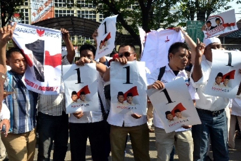 Relawan capres-Cawapres Prabowo-Hatta menunjukan nomer urut di kantor Komisi Pemilihan Umum (KPU), Jakarta, Ahad (1/6).