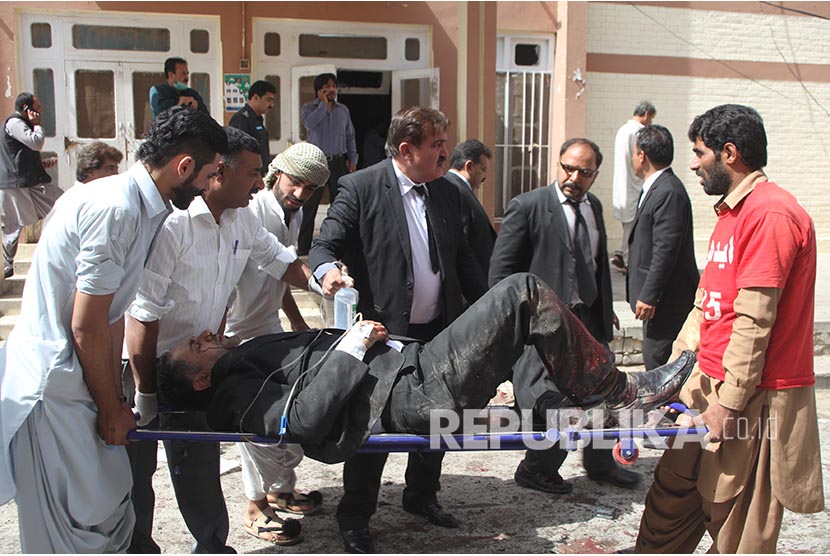 relawan dan petugas mengevakuasi korban ledakan bom di depan sebuah rumah sakit di Quetta, Pakistan, Senin (8/8).