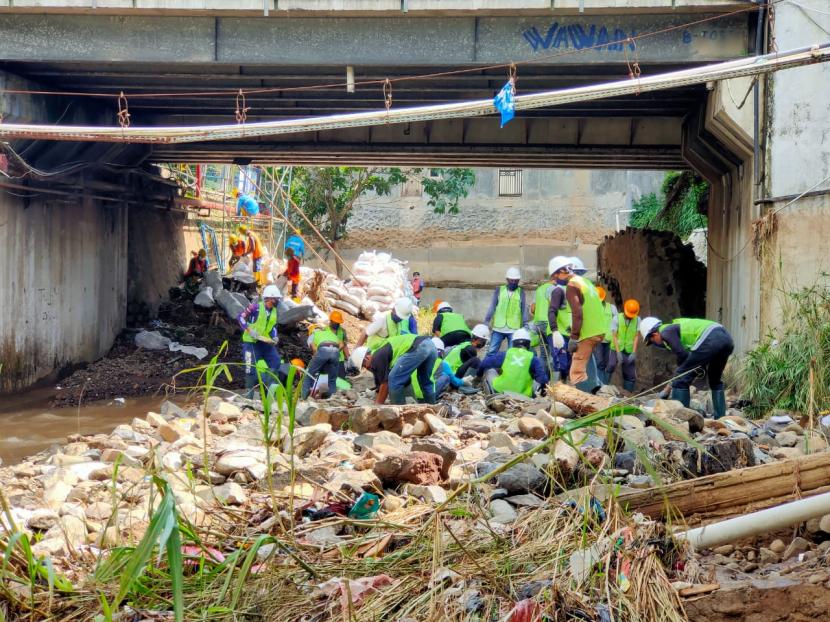 Relawan dari Pabrik Aqua Mekarsari dan Babakan Pari Sukabumu membersihkan tumpukan sampah yang menutupi sungai Cicatih pasca banjir bandang di Kecamatan Cicurug, Kabupaten Sukabumi.