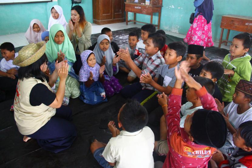 Relawan dari Universitas Gajah Mada (UGM) memberikan materi pemulihan psikologis pada anak pengungsi erupsi Gunung Semeru di Madrasah Ibtidaiyah Miftahul Ulum, Supiturang, Pronojiwo, Lumajang, Jawa Timur, Sabtu (1/1/2022). Pemulihan psikologis anak tersebut rencananya terus dilakukan hingga akhir Januari 2022 karena anak-anak pengungsi masih ketakutan melihat awan mendung dan petir pascaerupsi luncuran awan panas guguran (APG) Gunung Semeru.