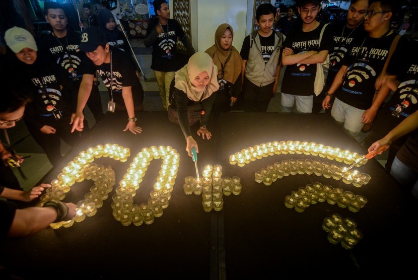 Relawan dari World Wide Fund for Nature (WWF) Indonesia menyalakan lilin saat perayaan Earth Hour di Bandung, Jawa Barat, Sabtu (30/3/2019). Tahun ini Earth Hour digelar virtual.