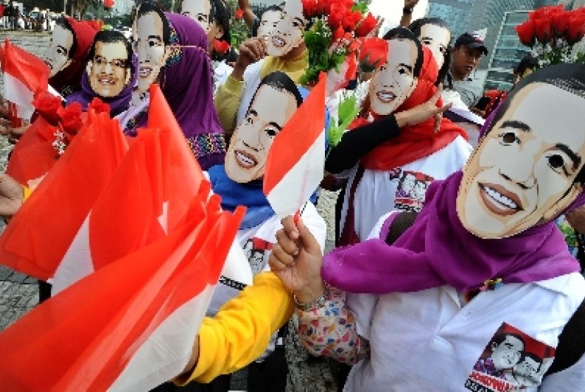 Relawan Forbes Jokowi mengunakan topeng saat aksi damai di Bundaran HI, Jakarta, Rabu (15/10). Mereka menyambut pelantikan presiden terpilih pada Senin (20/10).