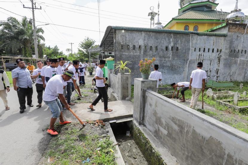Relawan gotong royong membersihkan area pemakaman bersama Remaja Masjid dan Badan Kemakmuran Masjid (BKM) Al Hakim, beserta puluhan warga Desa Kolam.