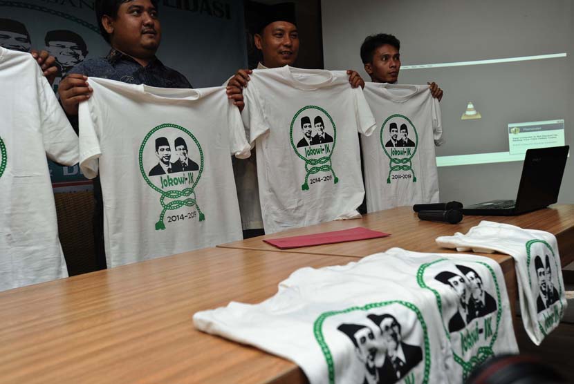 Relawan Keluarga Besar Nahdlatul Ulama (KBNU) memperlihatkan baju bergambar pasangan Capres dan Cawaprews saat memberikan dukungan di Jakarta, Senin (9/6).