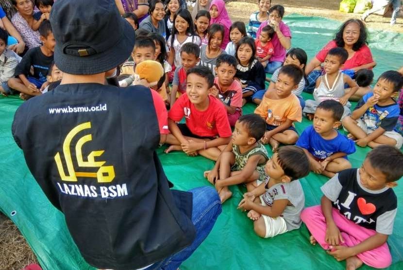 Relawan Laznas BSM memberikan MPASI untuk balita di pengungsian Lombok.