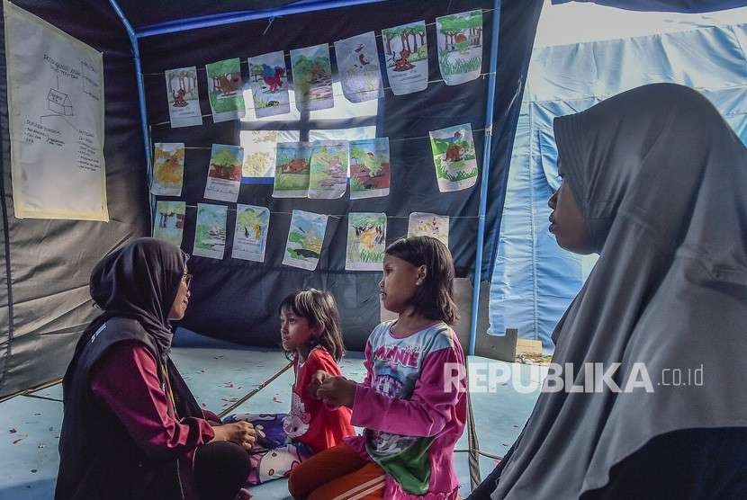 Relawan melakukan Trauma Healing dengan cara mengajak bermain anak-anak korban gempa tsunami Palu di kantor Dinas Sosial, Palu, Sulawesi Tengah, Jumat (5/10). 