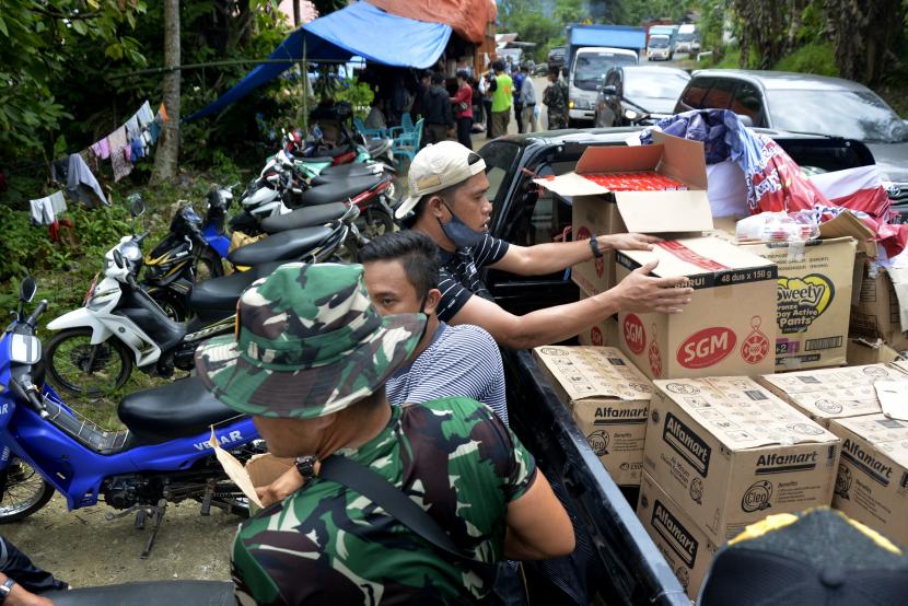 Relawan membagikan bantuan logistik kepada warga korban gempa bumi yang mengungsi di pinggir jalan poros trans Sulawesi, Kabupaten Mamuju, Sulawesi Barat, Rabu (20/1/2021). Bantuan untuk korban gempa bumi di Sulawesi Barat masih terus berdatangan dari sejumlah daerah.
