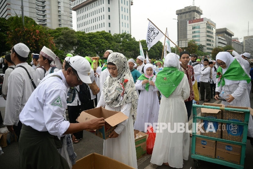 Relawan membagikan makanan dan minuman kepada peserta aksi super damai 212 di Jalan MH Thamrin, Jakarta, Jumat (2/12).
