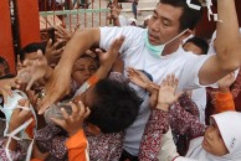 Relawan membagikan masker kepada siswa sekolah dasar (SD) di Alanglaweh, Padang, Sumatera Barat, Kamis (8/10).