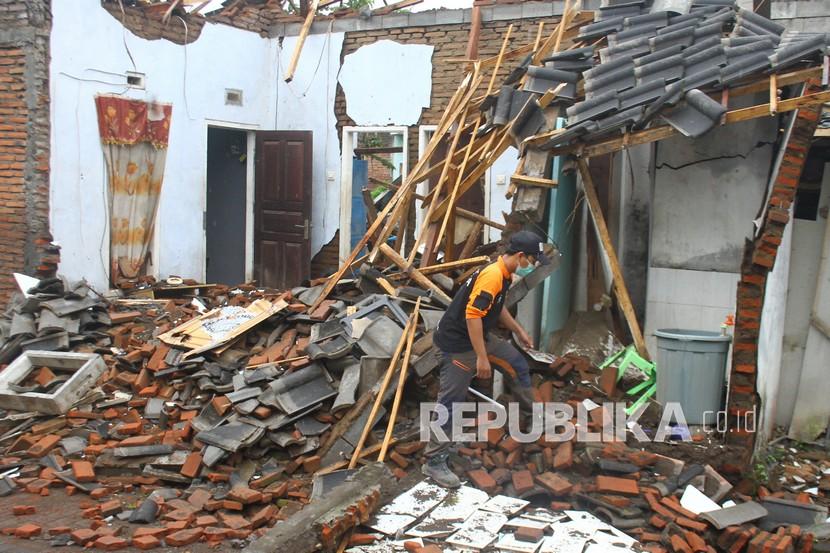 [Ilustrasi] Relawan membantu warga menyelamatkan barang di sebuah rumah yang hancur akibat gempa.
