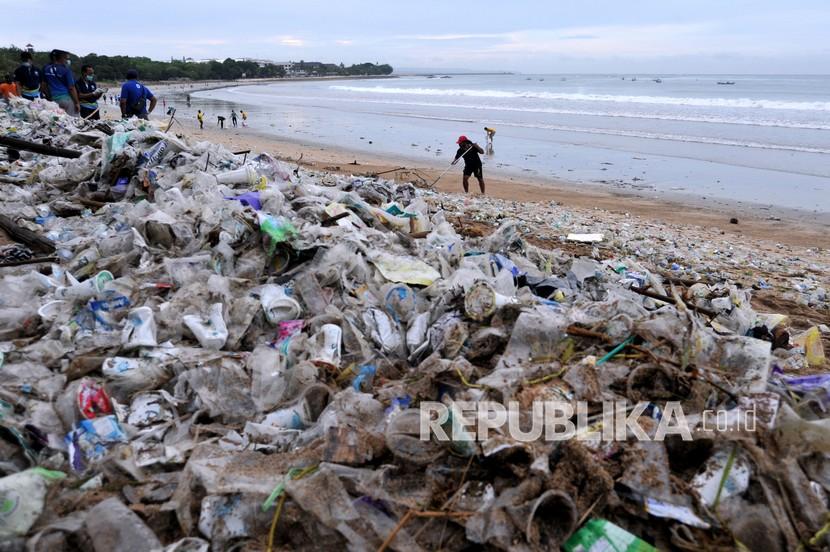 Relawan membersihkan sampah yang berserakan saat mengikuti aksi bersih sampah di Pantai Kuta, Badung, Bali.
