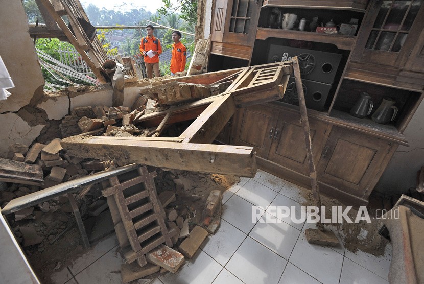 Relawan memeriksa rumah warga yang rusak akibat diguncang gempa di Kampung Karoya, Mandalawangi, Pandeglang, Banten, Sabtu (3/8/2019).