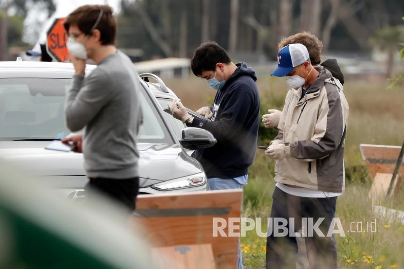 Relawan mengecek pengendara saat akan menjalani tes COVID-19 di Amerika Serikat 