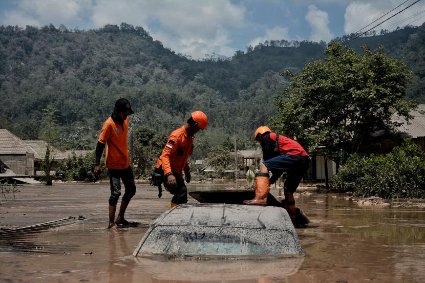 Relawan mengevakuasi kendaraan yang tertimbun longsoran material erupsi Gunung Semeru di Dusun Kamar Kajang, Desa Sumberwuluh, Kecamatan Candipuro, Kabupaten Lumajang, Jawa Timur.