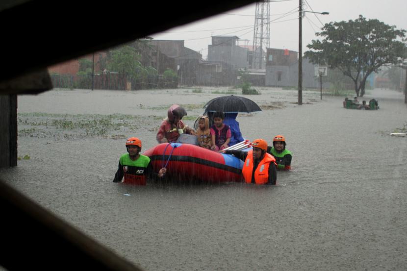 Relawan mengevakuasi warga menggunakan perahu karet saat banjir di Kelurahan Batua, Makassar, Sulawesi Selatan, Rabu (10/3/2021). Warga di daerah itu dievakuasi karena banjir setinggi satu meter merendam rumah mereka.