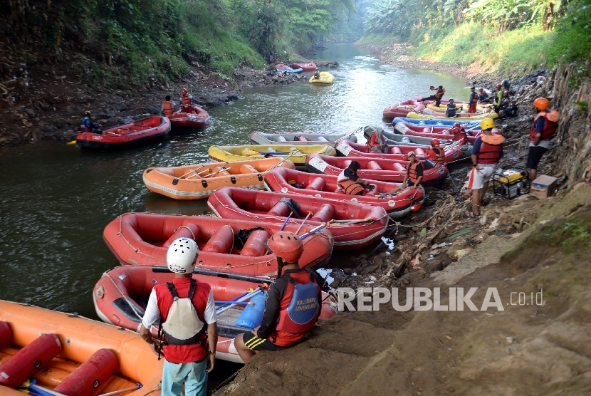  Relawan menggunakan perahu karet mengikuti Arung Sungai Ciliwung, Jakarta, Ahad (3/9). 