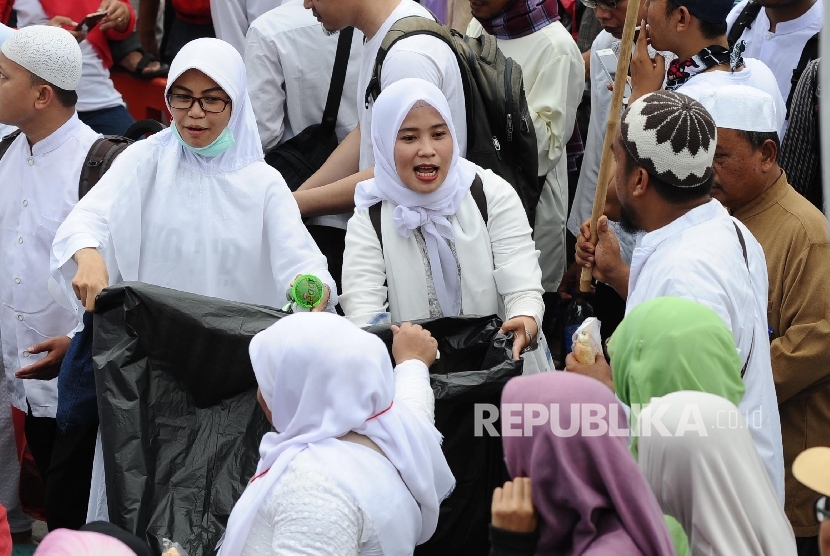  Relawan mengumpulkan sampah dari peserta saat melakukan longmarch aksi damai di Jalan Medan Merdeka Timur, Jakarta, Jumat (4\11).