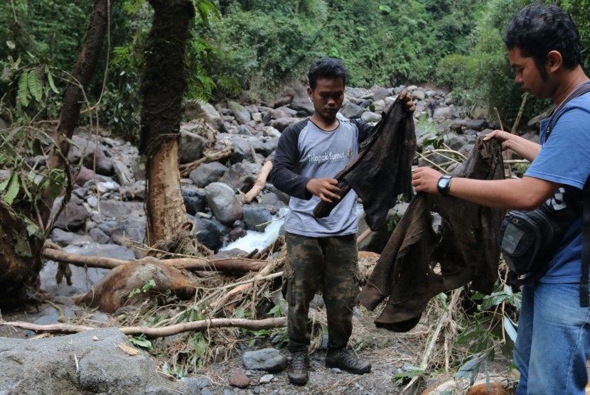 Relawan menunjukan baju korban banjir bandang di aliran Sungai Lau Mentar, Sibolangit, Deli Serdang, Sumatera Utara, Selasa (17/5).