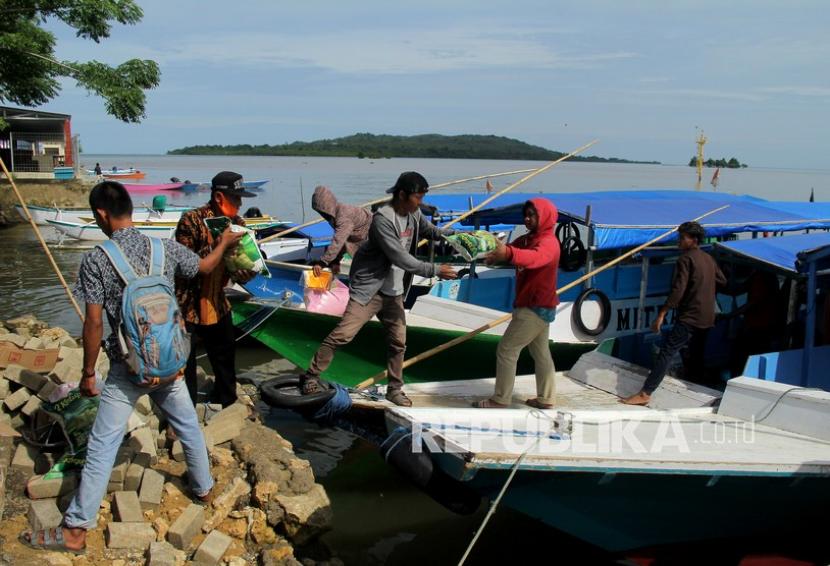 Relawan menyalurkan logistik di pelabuhan tradisional Mamuju, Sulawesi Barat, Senin (18/1/2021). Bantuan tersebut mulai disalurkan ke 17 pulau yang terdampak gempa bumi Mamuju-Majene. 