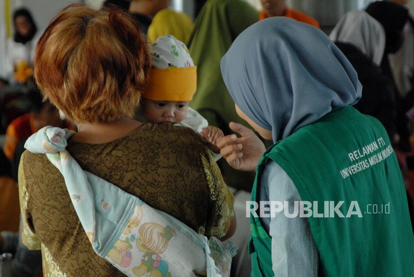 Relawan menyambut pengungsi korban kerusuhan Wamena saat tiba di Pelabuhan Sukarno Hatta, Makassar, Sulawesi Selatan, Jumat (4/10/2019). 