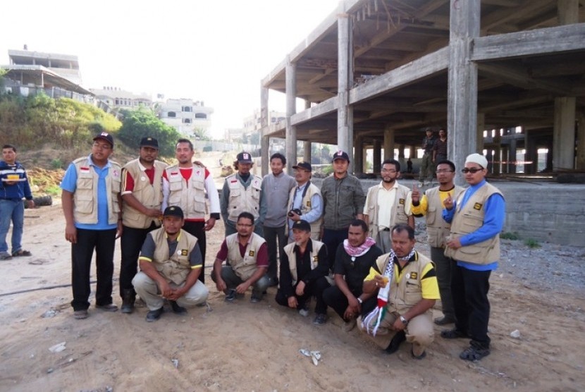 Relawan MER-C dan relawan LSM Haluan Malaysia berpose bersama di lokasi pembangunan RSI di Distrik Bayt Lahiya, Gaza utara, Palestina.