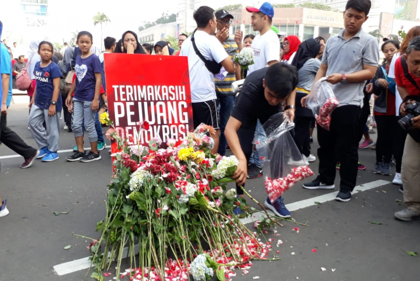 Relawan milenial Jokowi-Ma'ruf mengadakan aksi doa dan tabur bunga pada Ahad, (28/4) di kawasan bundaran HI Jakarta. Mereka mendoakan para penyelenggara pemilu yang sakit dan meninggal selama pemilu serentak 2019. 