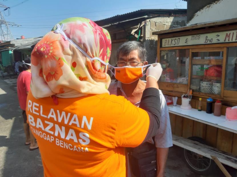 Relawan non medis memakaikan masker kepada masyarakat untuk menerapkan protokol kesehatan.