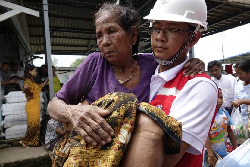 Relawan Palang Merah membawa seorang nenek ketika kapal feri tiba di Pelabuhan Sittwe, Sittwe, Negara Bagian Rakhine, Myanmar, 9 September 2017. Kapal feri itu membawa etnis Rakhine yang dipindahkan dari Kota Maungdaw. 