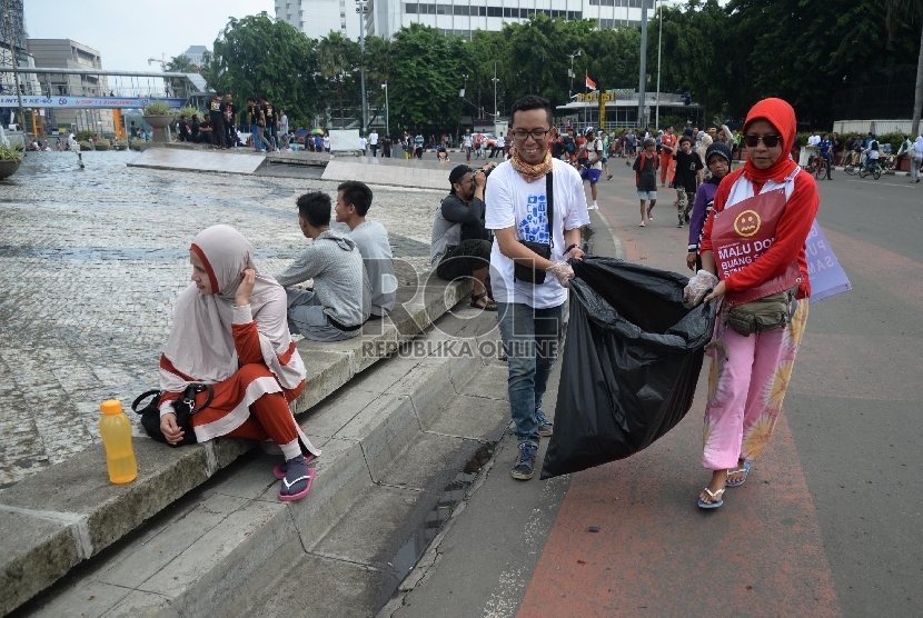 Relawan peduli Jakarta Bersih membersihan sampah yang berserakan di kawasan Hari Bebas Kendaraan Bermotor (HBKB) di Bundaran HI, Jakarta, Ahad (20/12). (Republika/Yasin Habibi)