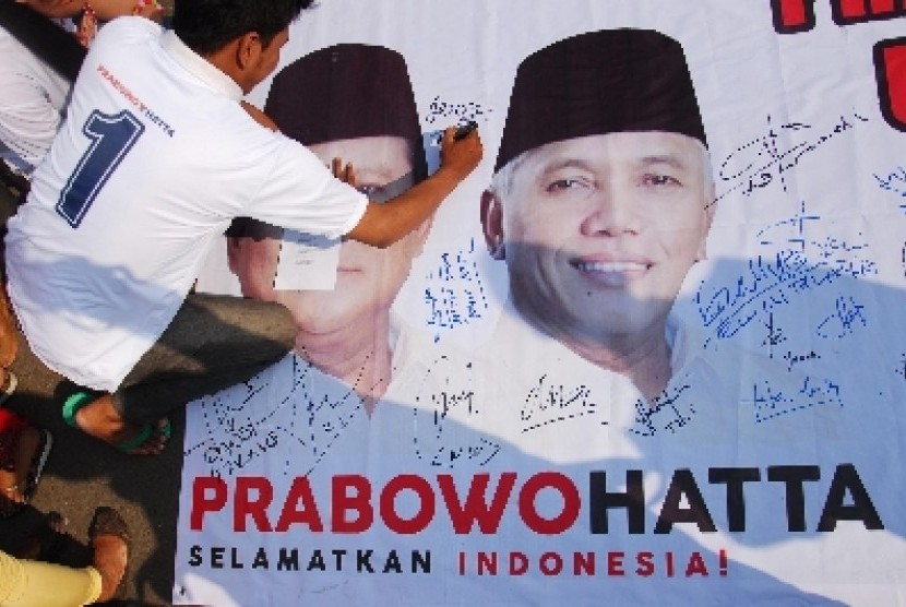 Relawan pendukung Prabowo-Hatta yang tergabung dalam Komunitas Masyarakat Penyelamat Indonesia (KOMPI) membubuhkan tanda tangan pada sebuah spanduk sebelum melakukan pawai dan aksi long march menuju Taman Ismail Marzuki, Jakarta, Sabtu (7/6).