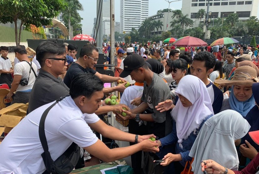 Relawan Pengusaha Muda Nasional (Repnas) DKI Jakarta membagi secara gratis ribuan gelas jus buah naga Banyuwangi dan varietas unggul apel Pasuruan di Car Free Day Jakarta, Ahad (24/2).