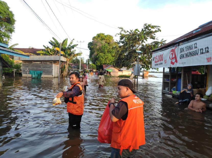 Relawan Rumah Zakat Action bersama relawan gabungan peduli banjir Sintang menyalurkan bantuan makanan cepat saji di kelurahan Mengkurai, Kecamatan Sintang, Kalimantan Barat. 