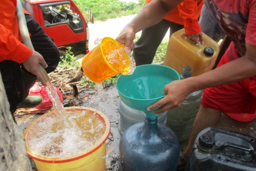 Relawan Rumah Zakat Action mendistribusikan air bersih untuk warga Kampung Bambu, Bekasi.