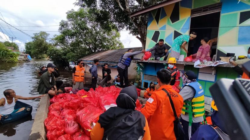 Relawan Rumah Zakat bersama Relawan lainnya memberikan bantuan kepada warga terdampak banjir di Kabupaten Sintang, Kalimantan Barat