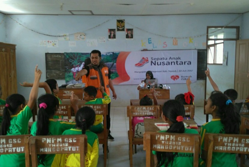 Relawan Rumah Zakat membagikan sepatu untuk siswa SDN Margopatut 6, Nganjuk, Jawa Timur.