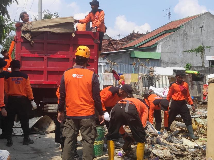 Relawan Rumah Zakat membersihkan rumah korban banjir Kecamatan Karanganyar.