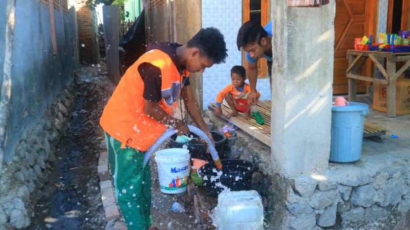 Relawan Rumah Zakat Sumbawa menyalurkan air bersih kepada korban bencana banjir Bima, Nusa Tenggara Barat (NTB), pada Senin (10/5). 