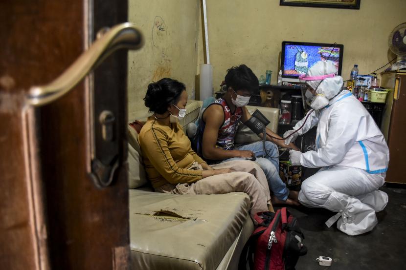 Relawan Satgas PPKM RW 10 memeriksa kesehatan pasien Covid-19 yang sedang menjalani isolasi mandiri (Isoman) di rumahnya di Jalan Kebon Bibit Selatan, Tamansari, Kota Bandung.