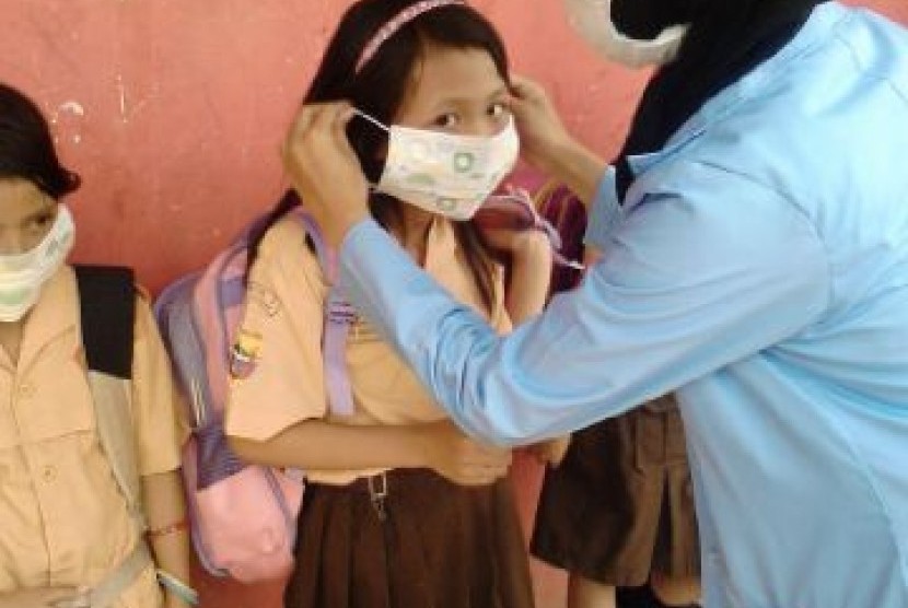 Relawan SIKAP memasangkan masker pada siswa SD yang ada di Palembang, Sabtu (17/10). 