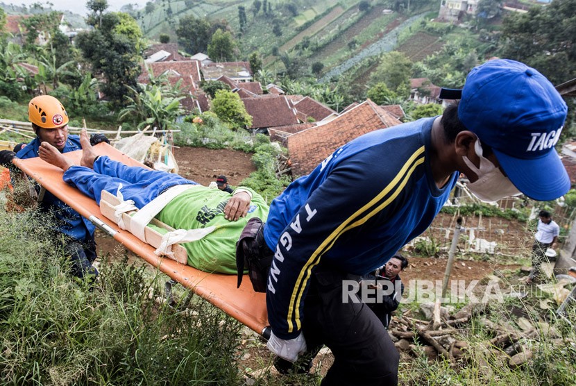 Relawan yang tergabung dalam tim gabungan melakukan evakuasi korban bencana gempa saat simulasi gempa bumi di kawasan Tebing Keraton, Ciburial, Kabupaten Bandung, Jawa Barat, Kamis (26/4).