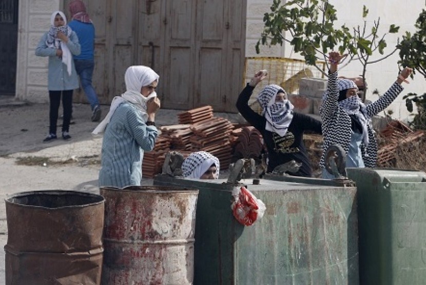 Remaja putri Palestina melemparkan batu ke aparat Israel di Kota Hebron (Ilustrasi)