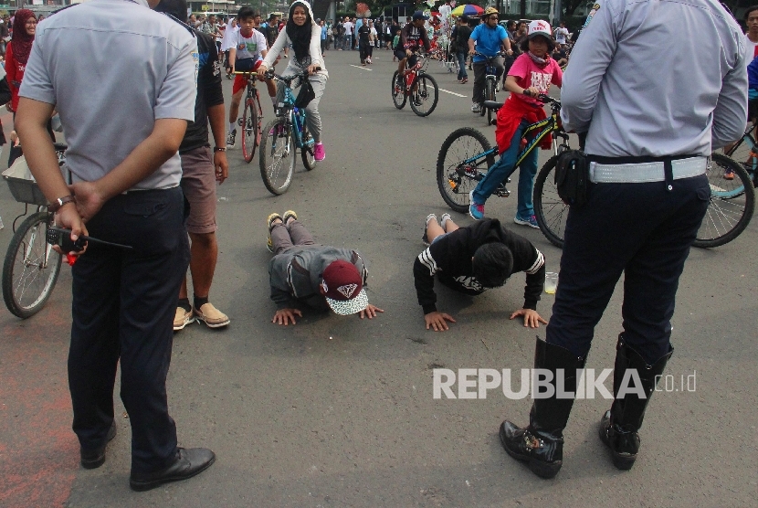 Remaja terkena hukuman push up sebanyak 20 kali akibat kedapatan merokok saat pelaksanaan Car Free Day di kawasan Bundaran HI, Jakarta, Ahad (22/5). (Republika/ Yasin Habibi)