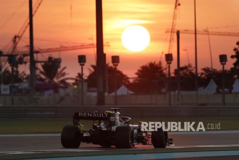 Pebalap Renault Nico Hulkenberg  memacu mobilnya dengan latar matahari terbenam di Lintasan Sirkuit Yas Marina, Abu Dhabi, United Arab Emirates, Jumat (29/11). 