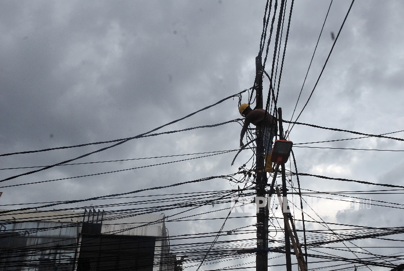 Petugas memperbaiki kabel listrik PLN. ilustrasi